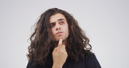 Studio, decision and man with question, confused or facial expression for doubt, unsure or thinking. Contemplating, serious and person with gesture for memory loss, uncertain and white backgroundの写真素材