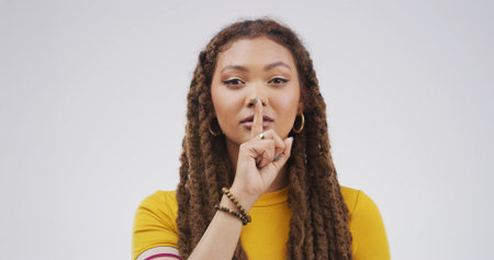 Portrait, finger on lips and woman with secret, whisper and privacy sign on white studio background....