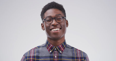 Portrait, nerd and black man in studio as student for scholarship, learning or college education. Smile, learner and geek with glasses for university with happiness on white background space in Kenyaの写真素材
