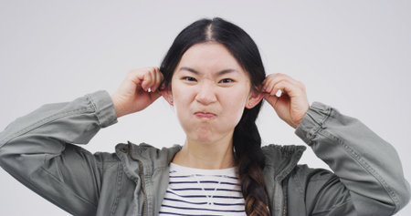 Studio, portrait and woman with funny face, silly or facial expression for humor, gesture or comic. White background, emoji and Asian person with reaction for comedy, goofy and confident in Chinaの写真素材