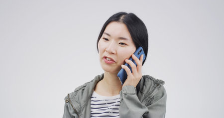 Phone call, studio and Asian woman with contact for communication, update or listening. Conversation, person and mobile for connection, advice or talk for information on white background with spaceの写真素材
