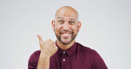 Happy man, portrait and pointing with surprise in studio for advertising on a white background. Male...