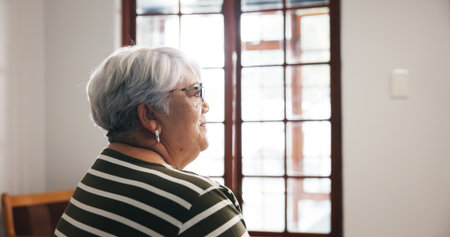 Thinking, elderly woman and smile at house with dementia, memory loss and nostalgia thoughts. Sad, senior person and reflection for loneliness, depression and decision for alzheimer treatmentの写真素材