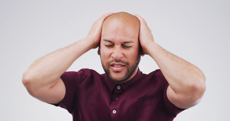 Pain, headache and man in studio with stress, frustrated or financial crisis with fail. Tension migraine, sick person and challenge with mistake, bankruptcy or debt with burnout on white backgroundの写真素材