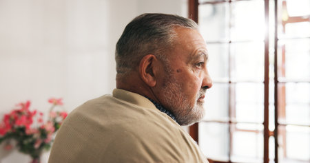 Sad, senior man and thinking in nursing home, loneliness and pensioner with Alzheimer and depressed. Mental health, reflection and old person with dementia, remember and retirement in house or aloneの写真素材