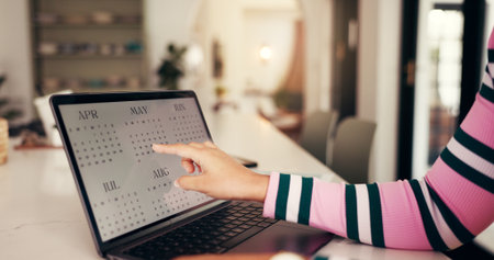 Hands, laptop and point at calendar for remote work from home, schedule and time management for project. Person, computer screen and check date for deadline, planning or reminder for job at apartmentの写真素材