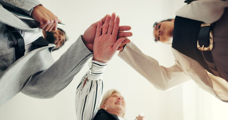 Hands stack, low angle and business people at office with team motivation, support and circle at...