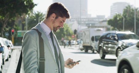 Businessman, smartphone and texting in street, travel and booking taxi on web for commute to workplace. Person, phone and profile in city with app for ride, transportation or check schedule in Spainの写真素材