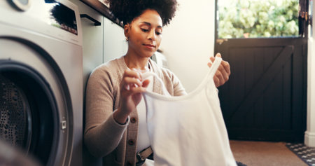 Laundry, woman and loading clothes in washing machine for housekeeping, fresh linen or hygiene. Maintenance, housewife and sort textiles in home for clean fabric, domestic chores or housework routineの写真素材