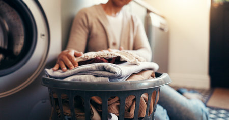Clothes, basket and laundry with hands of woman or washing machine for cleaning, hygiene and fabric softener. Housekeeping, cleaner or chores with person in home for washroom, linen or responsibilityの写真素材