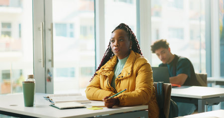 Girl, book and listen in classroom at university, study and development with education, info or knowledge. Person, college student and lesson with notebook, learning and attention for scholarshipの写真素材