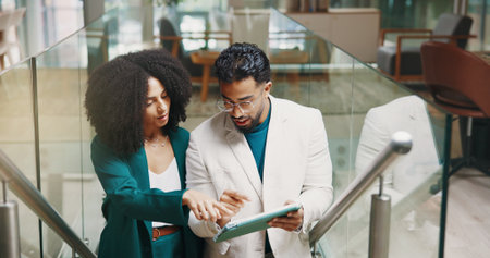 Teamwork, steps or business people with tablet for help, investment research or budget. Collaboration, advice and financial advisor in office lobby for news, accounting deadline or finance reportの写真素材