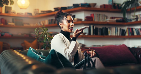 Happy, business woman and speaker with phone for audio message or communication on sofa in home. Female person, employee or user talking on mobile smartphone for voice note, app or chat in houseの写真素材