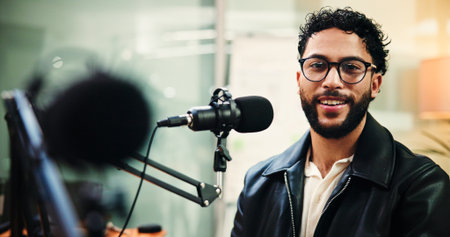 Microphone, podcast and portrait of man in recording studio for live streaming or radio broadcast. Content creation, glasses and smile with influencer person on air for journalism, media or talk showの写真素材