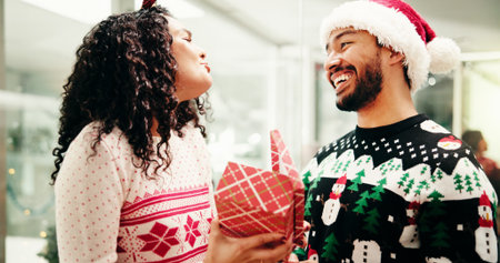 Christmas, box and happy business people in office for holiday, tradition and celebration. Professional, friends and man with woman for gift giving with gratitude, festive season and xmas partyの写真素材