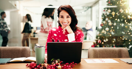 Portrait, employee and woman with laptop, Christmas and smile for work on festive season and office. Happy, marketing manager and mature person with Xmas sweater, pride or decor for December holidayの写真素材