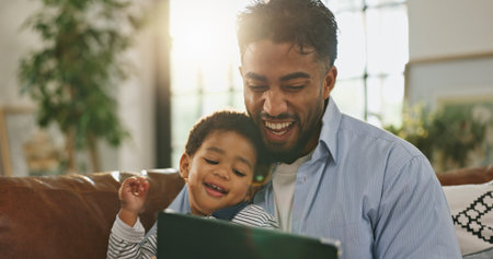 Father, boy and laugh with tablet on sofa for elearning video, bonding and relax in living room. Man, dad and child with tech, movies and streaming subscription with funny cartoon at family houseの写真素材