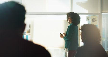 Happy woman, meeting or presentation with glass board for staff training, workshop or seminar. Female person, coach or teaching with group of employees for information, education or learning on spaceの写真素材