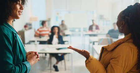 Classroom, teacher and listening to student, presentation or smile for oral in college or education. Talking, pupil and people with knowledge in university, speaker or answer for lesson or discussionの写真素材
