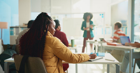 Education, back and writing with student in classroom for discussion, college or exam feedback. University lesson, scholarship opportunity and lecture with people learning on campus with professorの写真素材