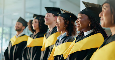 College, diversity and success with students at graduation for alumni ceremony, achievement and diploma pride. University, masters degree and academy milestone with people on campus for futureの写真素材