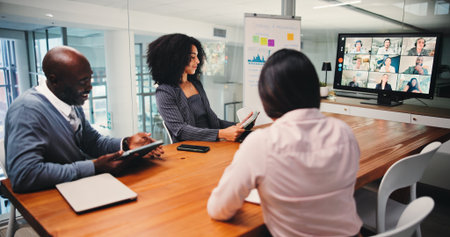 Boardroom, colleagues and group with tech, video call and communication with clients for investment. Business, meeting and people with tablet for virtual conference, discussion and pitch of proposalの写真素材