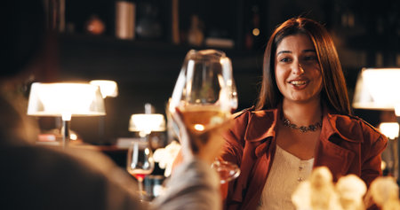 Woman, happy and toast on date at restaurant with wine glass, cheers and bonding for relationship goals. Girl, couple and alcohol with celebration, excited and romantic night with drinks at dinerの写真素材