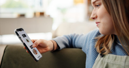 Woman, hands and phone screen with food menu for online restaurant or order on sofa in home. Female...