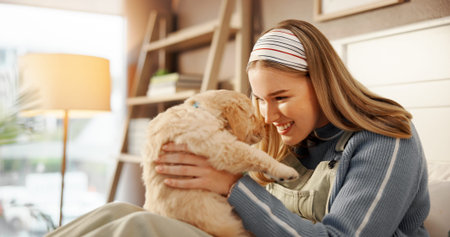 Love, bonding and woman with dog on bed for playing, connection or adoption in home together. Happy, relax and female person with Labrador puppy for pet, animal or companion in bedroom at house.の写真素材