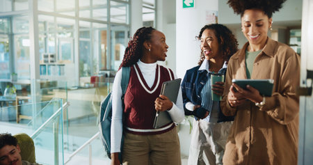 Women, students and walk with tablet at college for research, prepare for exam and study group. People, friends and project information, online results and education agenda for university assignmentの写真素材