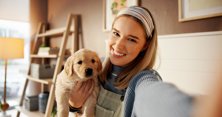 Selfie, smile and puppy with woman in home for social media post, pet influencer and love. Dog content creator, photography pov and golden retriever with person in apartment for animal care and trustの写真素材
