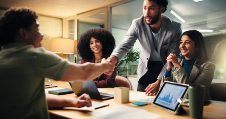 Shaking hands, deal and business people in office at night with finance statistics, graphs or team. Agreement, charts and financial manager with client for investment partnership with handshake.の写真素材