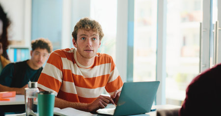 Man, college student and listen in classroom with laptop, notes and development with education....