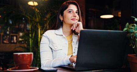 Ideas, laptop and remote work with woman in coffee shop for small business planning or research....