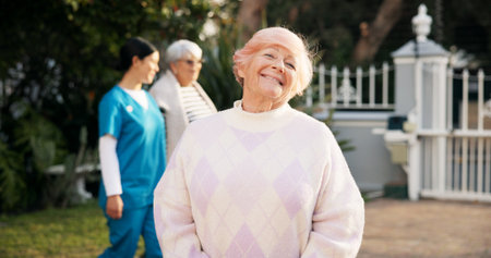 Portrait, nursing home and old woman with smile, backyard and confidence with pride. Face, people and elderly lady in garden, retirement and routine for daily movement, health and wellness with breakの写真素材