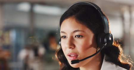 Woman, consultant and talking with headset in call center for online communication or advice in office. Female person, agent or employee speaking with mic for customer service or virtual assistanceの写真素材