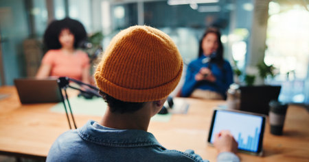 Podcast host, tablet and guests in studio for on air interview, talking and performance metrics. Radio show, tech screen and back of man with mic for live streaming, chat and listener demographicsの写真素材