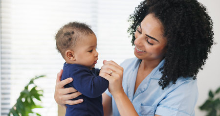Mother, happy and playing with baby in home for bonding together, security and connection. Love, family and woman with infant affection for protection, morning routine and child development in houseの写真素材