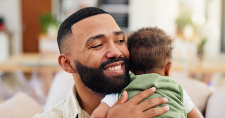 Happy, hug and dad with baby on sofa for bonding, loving relationship and development. Family, home and father with child embrace on couch for safety, support and care in living room togetherの写真素材