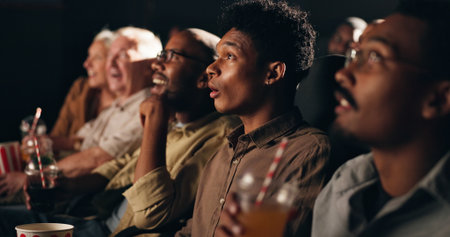Audience, watching movie and people in cinema, entertainment and expression with surprise. Crowd, shocked and group with fantasy film, relax and theater with reaction, show, snack or drink with mediaの写真素材