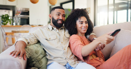 Happy couple, relax and watching tv with remote on sofa for movie, series or change channel in home....