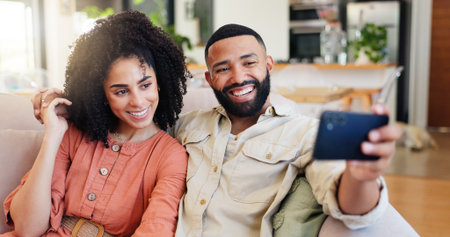 Happy couple, relax and sofa with selfie in home for picture, photography or memory together. Man, woman or lovers with smile or hug for capture moment, bonding or holiday break on couch in houseの写真素材