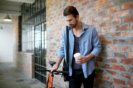 Businessman, coffee and waiting with bicycle in hallway for local commute or travel in office...