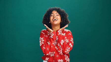 Woman, Christmas and portrait in studio, happy and culture with jumper for tradition on background. Girl, smile and celebration with mockup space, xmas and holiday with festive jersey in Costa Ricaの写真素材