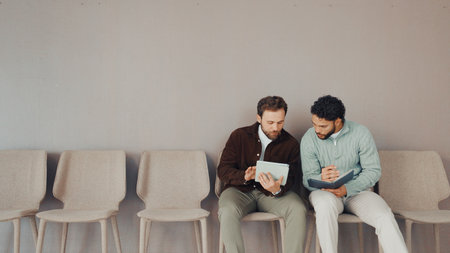 Tablet, hiring and waiting room with business men for recruitment, show cv or planning with space. Interview, queue and workers in collaboration with tech for hr, discussion or help with applicationの写真素材