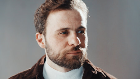 Thinking, serious and man in studio with memory, ideas or self reflection of nostalgia. Planning, choice and male person with face for solution, remember or problem solving by gray background.の写真素材