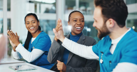 Woman, doctors and high five for celebration at meeting, achievement or congratulations at wellness clinic. People, medical staff and happy with group, thanks and team for goals in hospital boardroomの写真素材