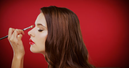 Woman, makeup brush and eyeshadow in studio for beauty with profile, tools and process on red background. Girl, cosmetic product and application for powder, change and aesthetic with mockup spaceの写真素材