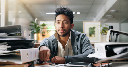 Stress, workload and businessman in office with burnout, fatigue and exhaustion for project deadline. Files, documents and professional financial manager with frustration for reports in workplace.の写真素材