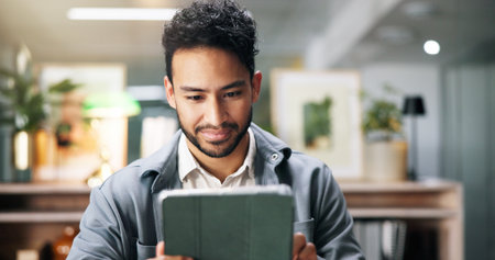 Creative man, reading and tablet in office for planning, proofreading story and editor feedback. Person, journalist and digital for research, article headlines and information on publication scheduleの写真素材